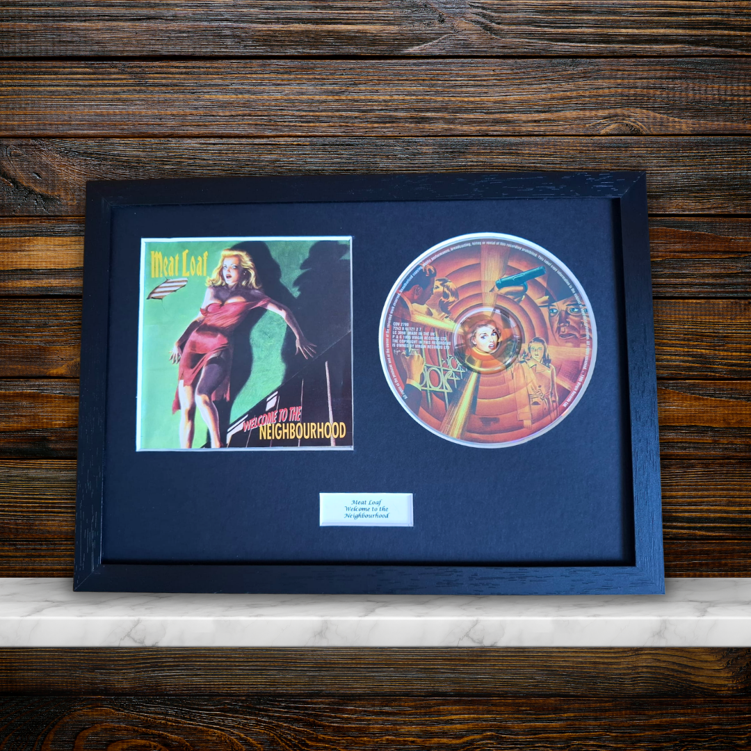 A framed Meat Load - Welcome To The Neighbourhood album collectible display, featuring the original vinyl record, the album cover art, and a small white plaque, set in a black frame against a dark wood background.